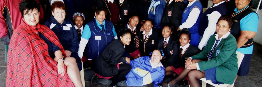 Die groep gemeenskaps-gesondheidwerkers in skooldrag tydens â€˜n werkswinkel, met voor links die kursusleier, Malinda Karsten en langs haar Ena Geldenhuys 